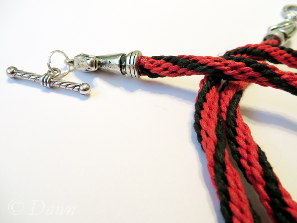 Cotton red and black Kuminimo cord  (inspired by the colours of Finish metal band Turisas) topped off with horse-head terminals 