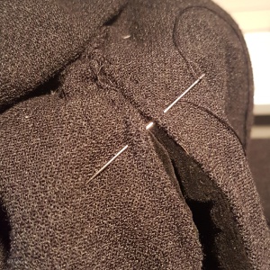 sewing a ladder stitch at the bottom of the neckline. The stitch isn't visible from the right side of the gown