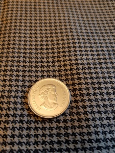 Tan & black houndstooth wool/silk blend fabric. Quarter for scale of weave