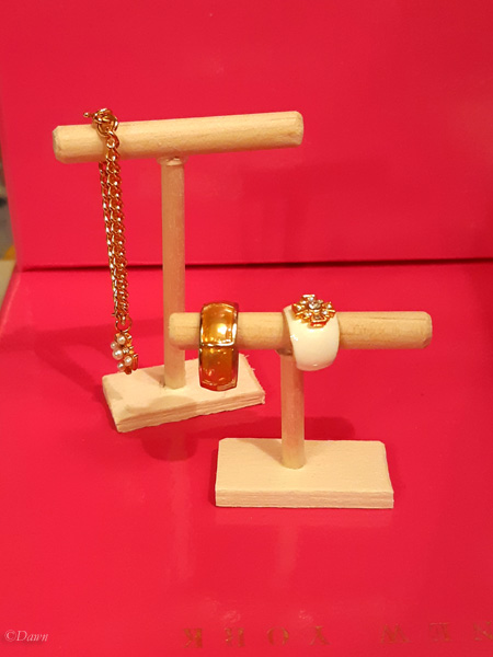 short and tall wooden necklace and bracelet display stands for doll dioramas.